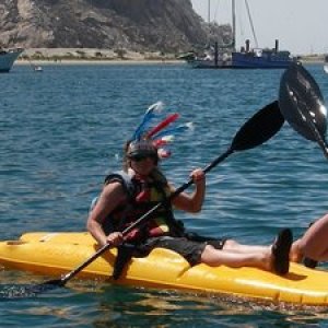 a group of people riding on the back of a boat in the water